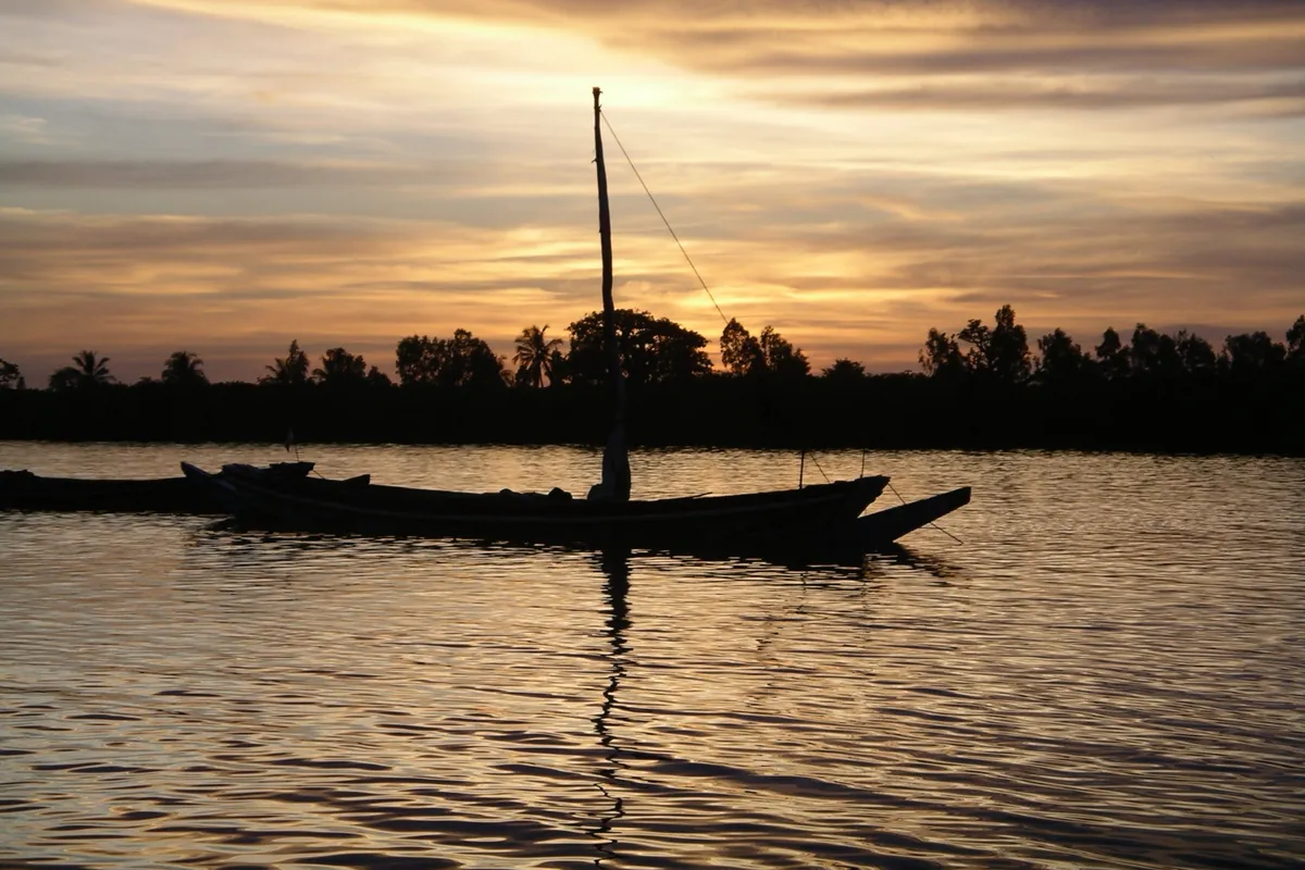 Une pirogue à voile au mouillage devant Niodior, dans les îles du Saloum, au coucher du soleil